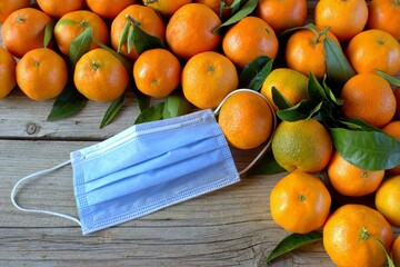 Fresh tangerines and medical mask. Virus protection.
