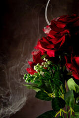 Cascade of smoke beautifully covering a bouquet of fabric flowers, abstract background, selective focus.