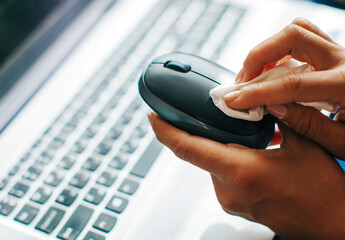 Covid-19 sanitizing office space wiping corona virus cleaning and disinfection of your workspace. Disinfecting wipes to wipe surface of desk, keyboard, mouse at office. Stop the spread of coronavirus.