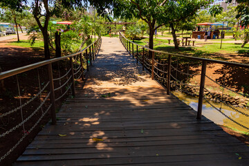 Fototapeta na wymiar Ponte de madeira sobre um córrego em parque na cidade de Anápolis no estado de Goiás.