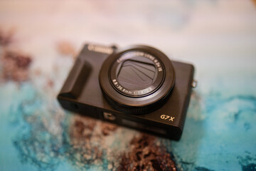 Modern and black pocket camera on a colorful placemat