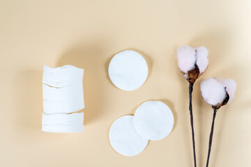 White organic cotton pads on a beige background.