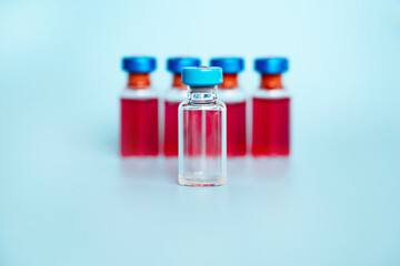 used ampoule on the background of full ampoules on a blue background