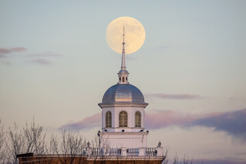 Full moon rising behind a beautiful building with a white steeple. Garden City, New York - obrazy, fototapety, plakaty