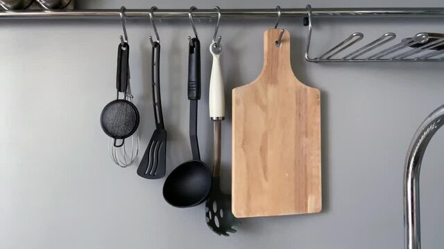 Slow motion footage with kitchenware swinging on a special kitchen bar with natural lighting 