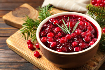 Fresh cranberry sauce with rosemary on wooden board