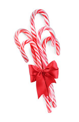 Sweet Christmas candy canes with red bow on white background, top view