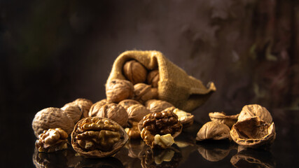 Nuts, details of nuts scattered on a black reflective surface, abstract background, selective focus.