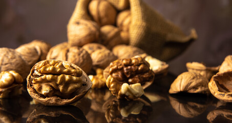 Nuts, details of nuts scattered on a black reflective surface, abstract background, selective focus.