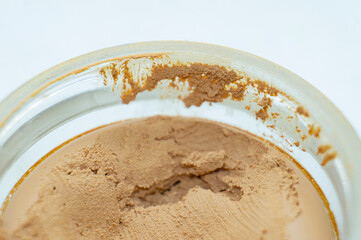 Brown skin care cream in a round jar