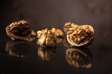 Nuts, walnuts scattered on a reflective black surface, abstract background, selective focus.