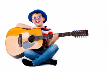 Obraz na płótnie Canvas A boy kid holding guitar on a white studio background