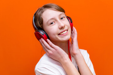 Fototapeta premium Attractive 12s girl in white t-shirt listens to music on headphones closeup