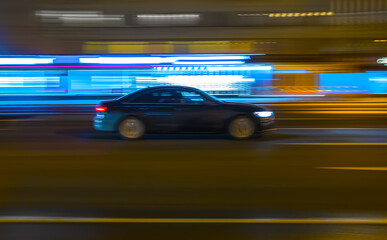 Fototapeta na wymiar car drives along a city street at night.