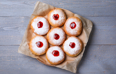 Hanukkah doughnuts with jelly and sugar powder on grey wooden table, top view