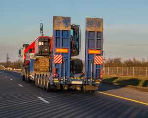 truck transports an excavator on a trailer