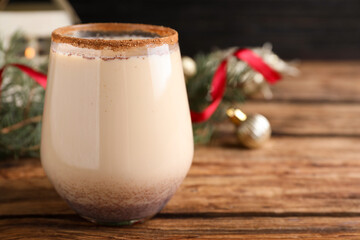 Delicious Christmas liqueur on wooden table, closeup. Space for text