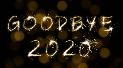 Goodbye 2020. Bright text made of sparkler on black background with blurred lights, banner design