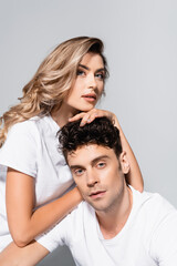 Fototapeta premium couple in white t-shirts embracing isolated on grey