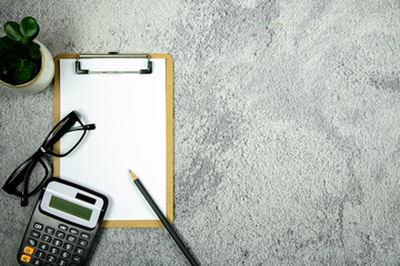 A notebook with pencil, calculator and eye glasses on the desk. - Business concept.