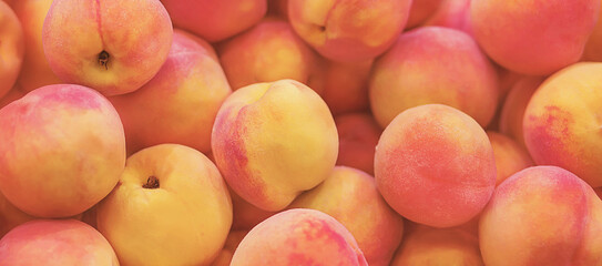 The harvest of sweet tropical fruit. Delicious tender ripe peaches are in the grocery store. Background.