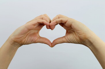 close-up, woman's hands are making the heart symbol