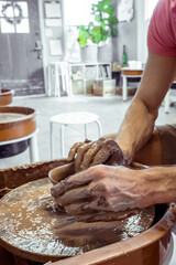 Close-up of making clay pottery. The sculptor in the workshop sculpts a clay jug close-up. Twisted potter's wheel. Artistic creation Cultural tradition Handicraft Hands of a craftsman