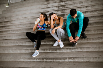 Young people resting during training with bottle of water