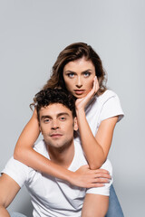 Fototapeta premium couple in white t-shirts embracing isolated on grey