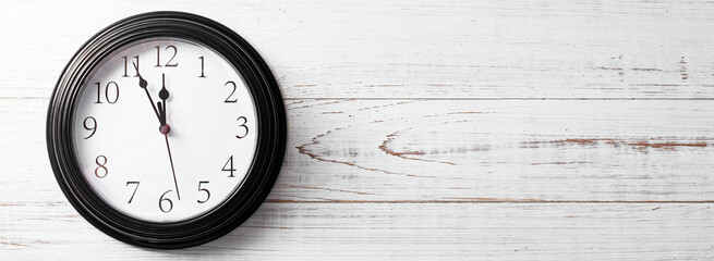 Clock on a white background. A minute to twelve. Banner. Place for your text.