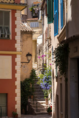 Fototapeta na wymiar Charming colorful alley corner of traditional old houses and public staircase in beautiful medieval village of Gourdon, in the French department of Alpes-Maritimes. World's attractive destinations