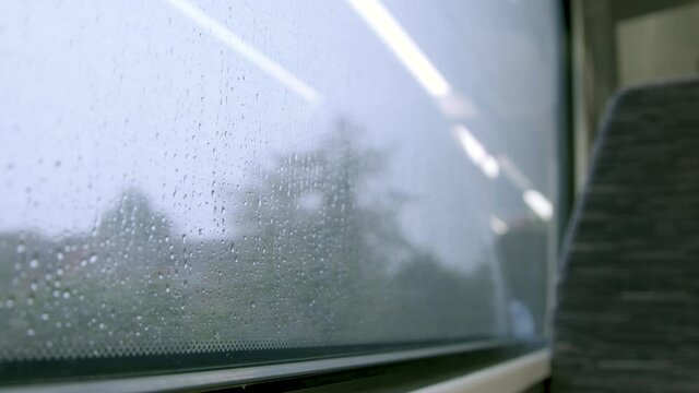 Looking out a train window while it rains outside