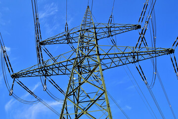 Ein 380-kv-Starkstromleitungsmast vor blauem Himmel
