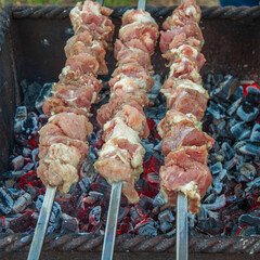 Three skewers with marinated meat on the grill