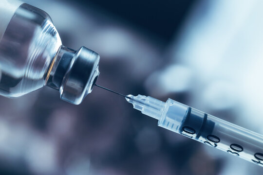 Syringe draws vaccine from ampoule. Coronavirus and flu cure. Close-up view