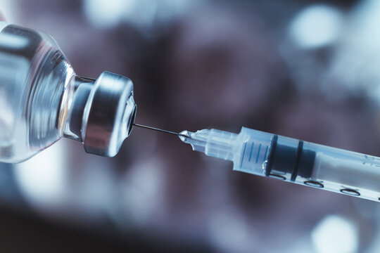 Syringe draws vaccine from ampoule. Coronavirus and flu cure. Close-up view.