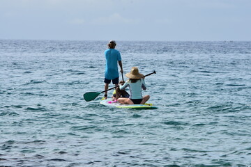Family paddle boarding off the shores of south Maui, Hawaii