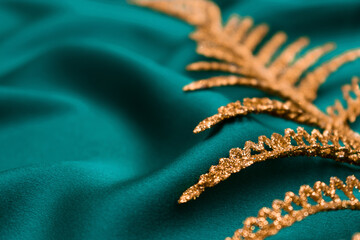 Creative blurred background of  green silk and golden fern leaf. Abstract texture.Tidewater green color of the year 2021.Selective focus with shallow depth of field,copy space.