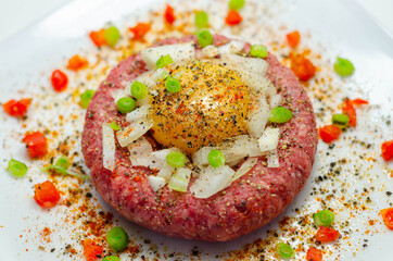 Beef steak tartare with raw egg yolk and onion with tomato