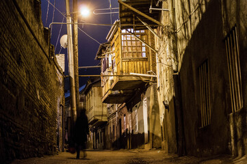 Scary dark street in Tbilisi, glowing lamp, Georgia