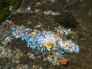Top drone view of dumping site. A lot of garbage on landfill of big city. Plastic trash bags and paper waste. Waste sorting.