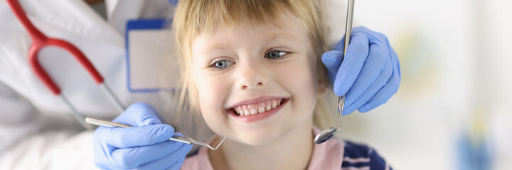 Little girl smiles at dentist appointment. Dental treatment in children concept