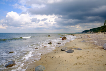 Waving sea and sandy shore on cloudy day