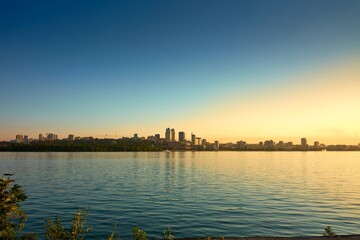 Naklejka premium sunset, water, city, sky, river, night, landscape, dusk, sea, sun, skyline, reflection, travel, blue, lake, beach, cityscape, urban, building, nature, bridge, evening, sunrise, harbor