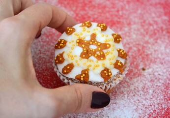 Christmas composition: Christmas cupcake decorated with icing and a female hand holding it