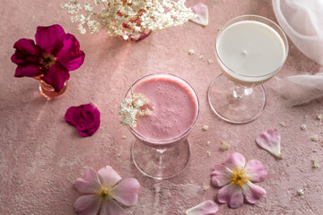 Obraz na płótnie Canvas A glass of goats milk kefir with blended raspberries on a pink background