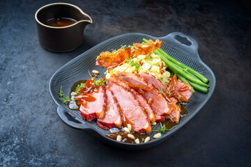 Modern Style traditionelles Gourmet Eintenbrust Filet mit Kartoffelsalat und Bohnen in Orangen Sauce serviert als close-up auf einem Design Teller