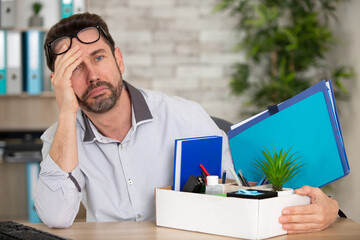 sad man with his office possessions in a box