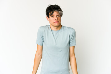 Young skinny hispanic man shrugs shoulders and open eyes confused.