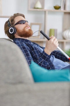 Blind Man Sitting On Sofa At Home